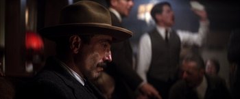 Movie still from “There Will Be Blood” (2007), directed by Paul Thomas Anderson – A man with a mustache wearing a brown hat; Close Up shot, Over the shoulder angle