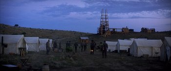 Movie still from “There Will Be Blood” (2007), directed by Paul Thomas Anderson – A group of people standing on top of a grass covered field; Extreme Wide shot, High angle