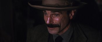 Movie still from “There Will Be Blood” (2007), directed by Paul Thomas Anderson – A person wearing a hat and a tie; Close Up shot, High angle