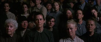 Movie still from “There Will Be Blood” (2007), directed by Paul Thomas Anderson – A group of people standing in a dark room; Medium shot, High angle