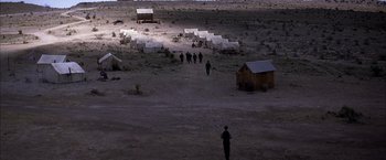 Movie still from “There Will Be Blood” (2007), directed by Paul Thomas Anderson – A group of people walking across a dirt field; Extreme Wide shot, High angle