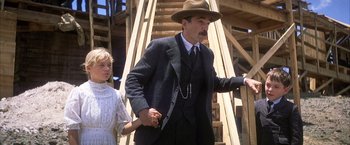 Movie still from “There Will Be Blood” (2007), directed by Paul Thomas Anderson – A man and a girl in a suit and hat; Medium shot, Low angle