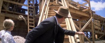 Movie still from “There Will Be Blood” (2007), directed by Paul Thomas Anderson – A man wearing a hat walking up a set of stairs; Close Up shot, Over the shoulder angle