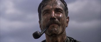 Movie still from “There Will Be Blood” (2007), directed by Paul Thomas Anderson – A person holding a pipe in his mouth; Close Up shot, Low angle