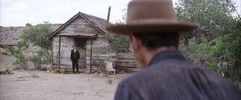 Movie still from “There Will Be Blood” (2007), directed by Paul Thomas Anderson – A man standing in front of an old house; Wide shot, Over the shoulder angle
