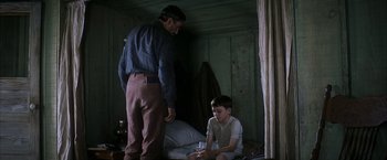 Movie still from “There Will Be Blood” (2007), directed by Paul Thomas Anderson – A man and a young boy sitting on the floor of a room; Medium shot, Over the shoulder angle