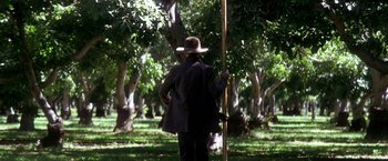 Movie still from “There Will Be Blood” (2007), directed by Paul Thomas Anderson – A man with a hat and a stick in a field; Wide shot, Low angle