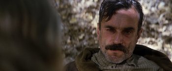 Movie still from “There Will Be Blood” (2007), directed by Paul Thomas Anderson – A person with a mustache; Close Up shot, Over the shoulder angle