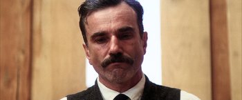 Movie still from “There Will Be Blood” (2007), directed by Paul Thomas Anderson – A person wearing a suit and tie; Close Up shot, Low angle