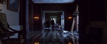Movie still from “There Will Be Blood” (2007), directed by Paul Thomas Anderson – A man and a dog are in a dark room; Wide shot, Low angle
