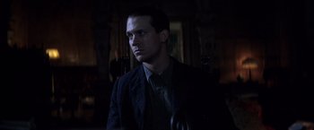 Movie still from “There Will Be Blood” (2007), directed by Paul Thomas Anderson – A man in a suit and tie looking to his left; Close Up shot, Low angle