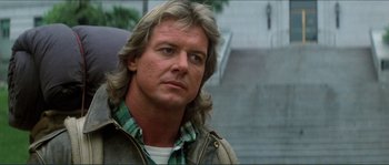 Movie still from “They Live” (1988), directed by John Carpenter – A person with long hair; Close Up shot, Low angle