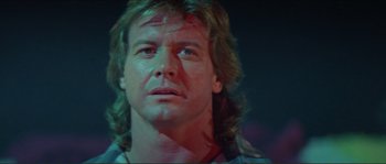 Movie still from “They Live” (1988), directed by John Carpenter – A person with long hair; Close Up shot, Low angle