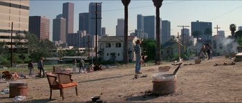 Movie still from “They Live” (1988), directed by John Carpenter – A person on a skate board in the dirt; Extreme Wide shot, High angle