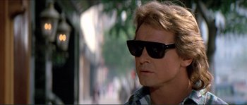 Movie still from “They Live” (1988), directed by John Carpenter – A person wearing sunglasses; Close Up shot, Over the shoulder angle