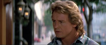 Movie still from “They Live” (1988), directed by John Carpenter – A person wearing a plaid shirt; Close Up shot, Over the shoulder angle