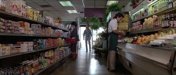 Movie still from “They Live” (1988), directed by John Carpenter – A group of people standing in a grocery store aisle; Wide shot, Low angle