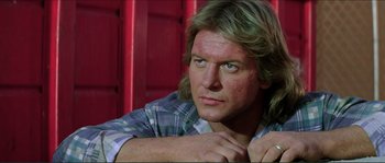 Movie still from “They Live” (1988), directed by John Carpenter – A person with long blonde hair; Close Up shot, Low angle