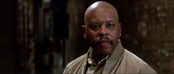 Movie still from “They Live” (1988), directed by John Carpenter – A bald man with a mustache and a beard; Close Up shot, Low angle