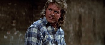 Movie still from “They Live” (1988), directed by John Carpenter – A person wearing a plaid shirt; Close Up shot, Over the shoulder angle