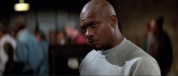 Movie still from “They Live” (1988), directed by John Carpenter – A man with a bald head is looking to his left; Close Up shot, Low angle