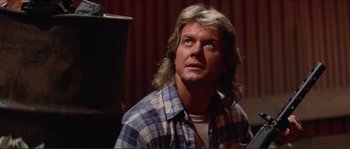 Movie still from “They Live” (1988), directed by John Carpenter – A person wearing a plaid shirt; Close Up shot, Low angle