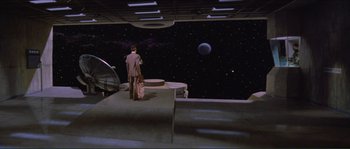 Movie still from “They Live” (1988), directed by John Carpenter – A man and a woman standing in front of a space ship; Extreme Wide shot, High angle