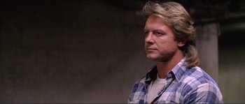 Movie still from “They Live” (1988), directed by John Carpenter – A person wearing a plaid shirt; Close Up shot, Low angle