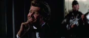 Movie still from “They Live” (1988), directed by John Carpenter – A person wearing a suit and tie; Close Up shot, Low angle