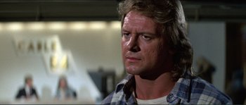 Movie still from “They Live” (1988), directed by John Carpenter – A person wearing a plaid shirt; Close Up shot, Low angle