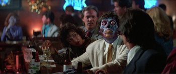 Movie still from “They Live” (1988), directed by John Carpenter – A group of people sitting at a table with drinks; Close Up shot, Over the shoulder angle
