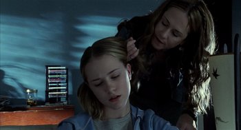 Movie still from “Thirteen” (2003), directed by Catherine Hardwicke – A woman is combing another woman's hair in a room; Close Up shot, Over the shoulder angle
