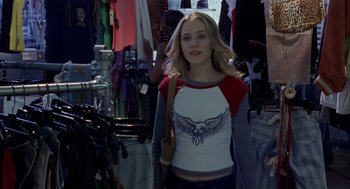 Movie still from “Thirteen” (2003), directed by Catherine Hardwicke – A woman is standing next to a bunch of clothes; Medium shot, Over the shoulder angle