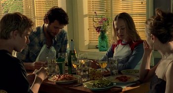 Movie still from “Thirteen” (2003), directed by Catherine Hardwicke – A man and a woman sitting at a table with plates of food on it; Medium shot, High angle