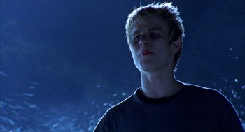 Movie still from “Thirteen” (2003), directed by Catherine Hardwicke – A young man standing in the dark looking up at the sky; Close Up shot, Low angle