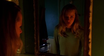 Movie still from “Thirteen” (2003), directed by Catherine Hardwicke – A woman standing in front of a bathroom mirror; Medium shot, Low angle