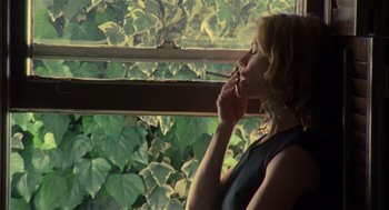 Movie still from “Thirteen” (2003), directed by Catherine Hardwicke – A woman smoking a cigarette in front of a window; Medium shot, Low angle