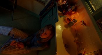 Movie still from “Thirteen” (2003), directed by Catherine Hardwicke – A woman standing next to a sink in a bathroom; Medium shot, Overhead angle