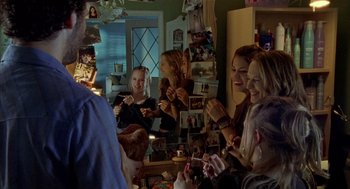 Movie still from “Thirteen” (2003), directed by Catherine Hardwicke – A group of people in a room with pictures on the wall; Medium shot, Over the shoulder angle