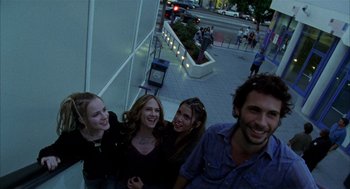Movie still from “Thirteen” (2003), directed by Catherine Hardwicke – A group of people standing next to each other on a sidewalk; Medium shot, Low angle