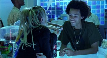 Movie still from “Thirteen” (2003), directed by Catherine Hardwicke – A young man and a little girl are laughing together; Medium shot, Over the shoulder angle