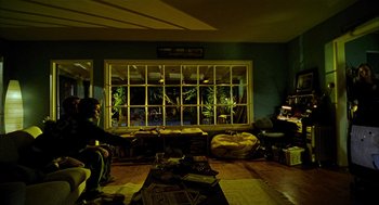 Movie still from “Thirteen” (2003), directed by Catherine Hardwicke – A living room filled with furniture next to a large window; Wide shot, High angle