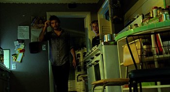 Movie still from “Thirteen” (2003), directed by Catherine Hardwicke – Two men standing in front of an oven in a kitchen; Medium shot, Low angle