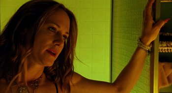 Movie still from “Thirteen” (2003), directed by Catherine Hardwicke – A beautiful woman in a green room with her arms up; Close Up shot, Low angle