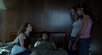 Movie still from “Thirteen” (2003), directed by Catherine Hardwicke – A man and two women stand in a bed next to another man; Medium shot, High angle