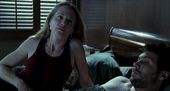 Movie still from “Thirteen” (2003), directed by Catherine Hardwicke – A woman sitting on a bed with a man laying on the bed; Medium shot, Over the shoulder angle