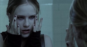Movie still from “Thirteen” (2003), directed by Catherine Hardwicke – A woman with her hand on her face in front of a bathroom mirror; Close Up shot, Over the shoulder angle