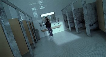 Movie still from “Thirteen” (2003), directed by Catherine Hardwicke – A person taking a picture in a mirror in a bathroom; Wide shot, High angle