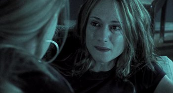 Movie still from “Thirteen” (2003), directed by Catherine Hardwicke – A woman's face in a dark room; Close Up shot, Over the shoulder angle