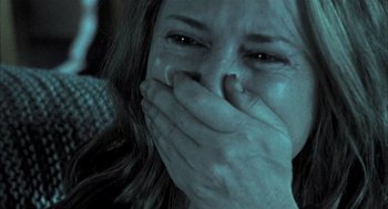 Movie still from “Thirteen” (2003), directed by Catherine Hardwicke – A woman covers her mouth with her hands; Close Up shot, Over the shoulder angle